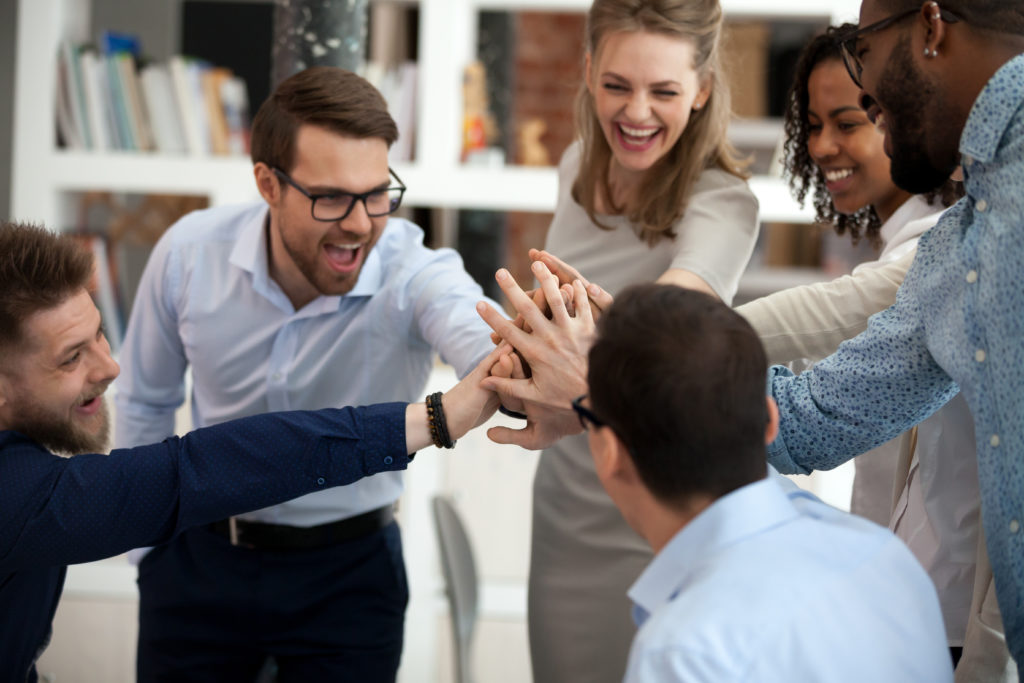 Excited motivated diverse team people give high five in office