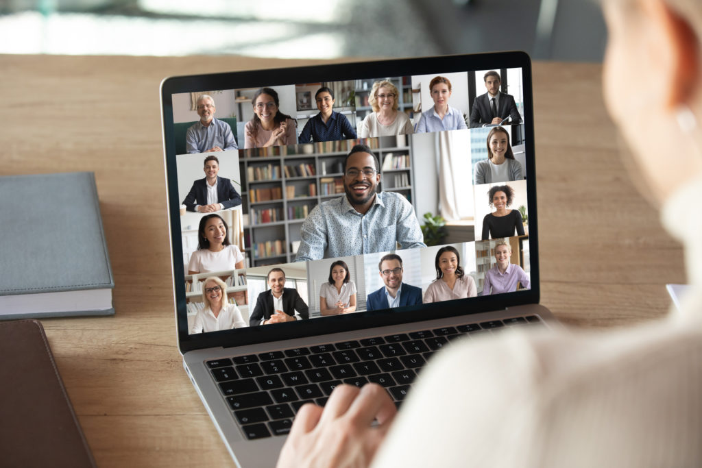 A laptop showing a video call full of coworkers.