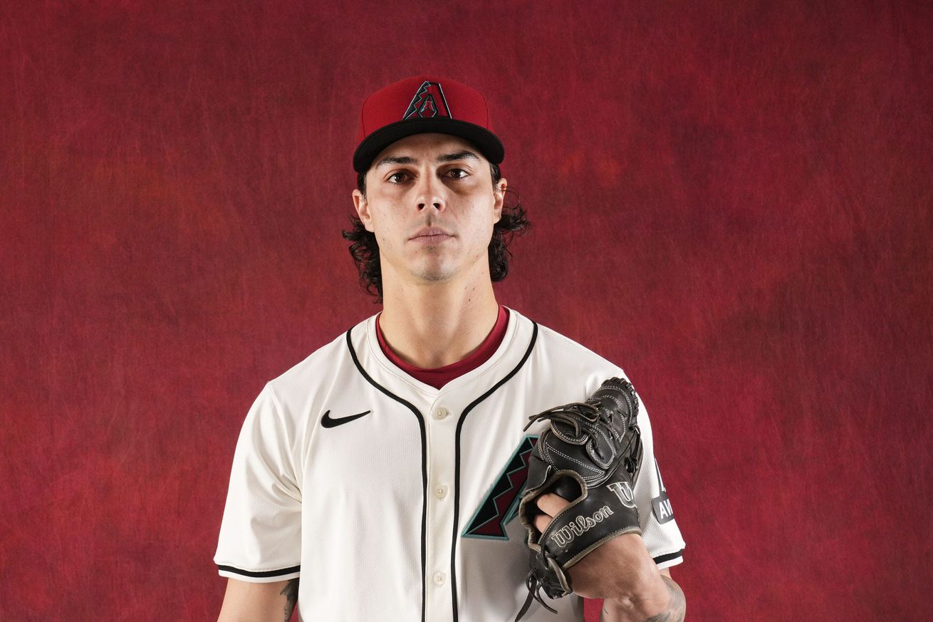 Dakota Chalmers with glove on left hand and baseball in right, looking directly at camera