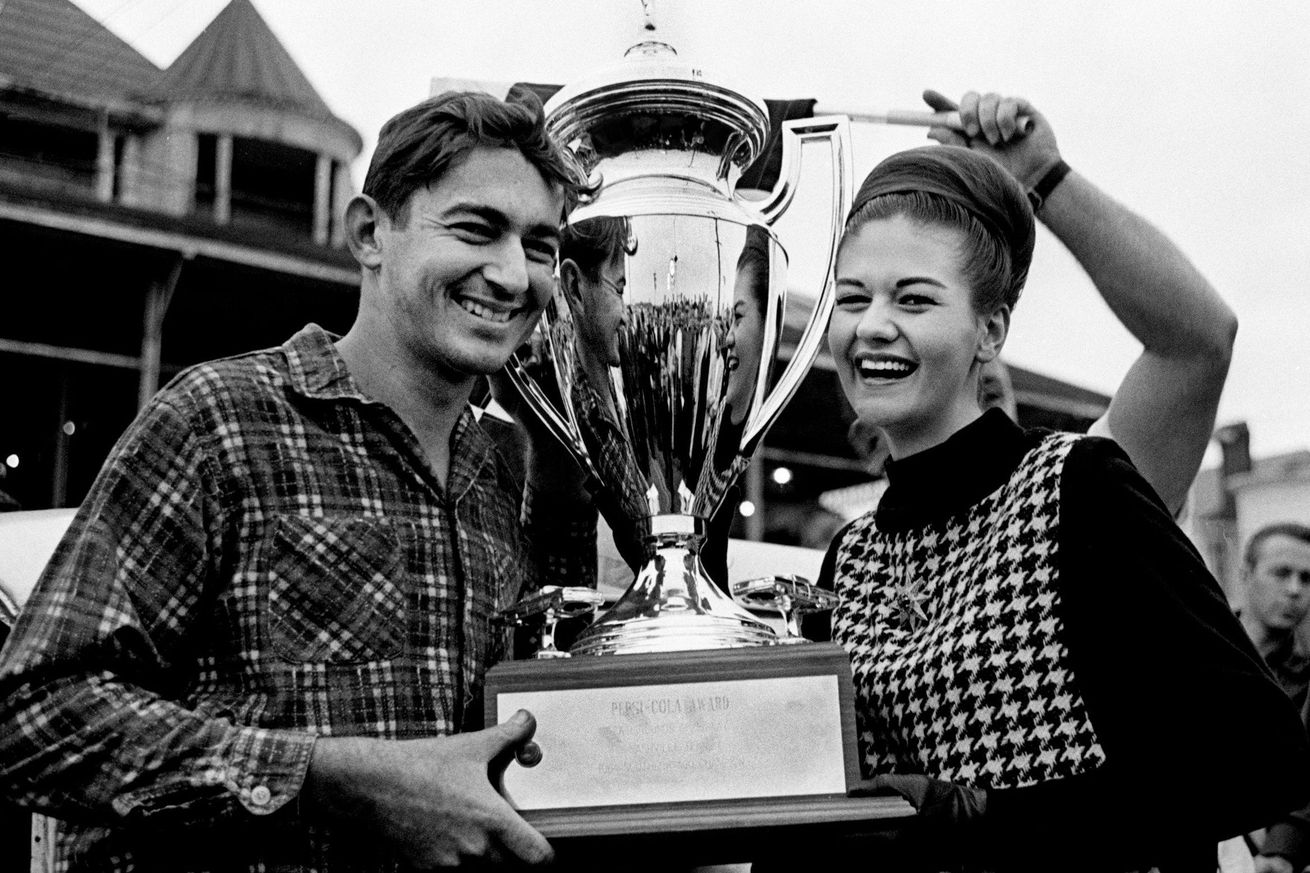 Bobby Allison holding the trophy for winning the Souther 300  in 1964. He is also being presented a $1000 check