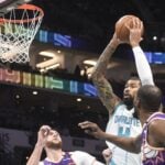 Jan 7, 2025; Charlotte, North Carolina, USA; Charlotte Hornets center Nick Richards (4) looks to pass a rebound during the first half against the Phoenix Suns as Nurkic looks on at the Spectrum center.