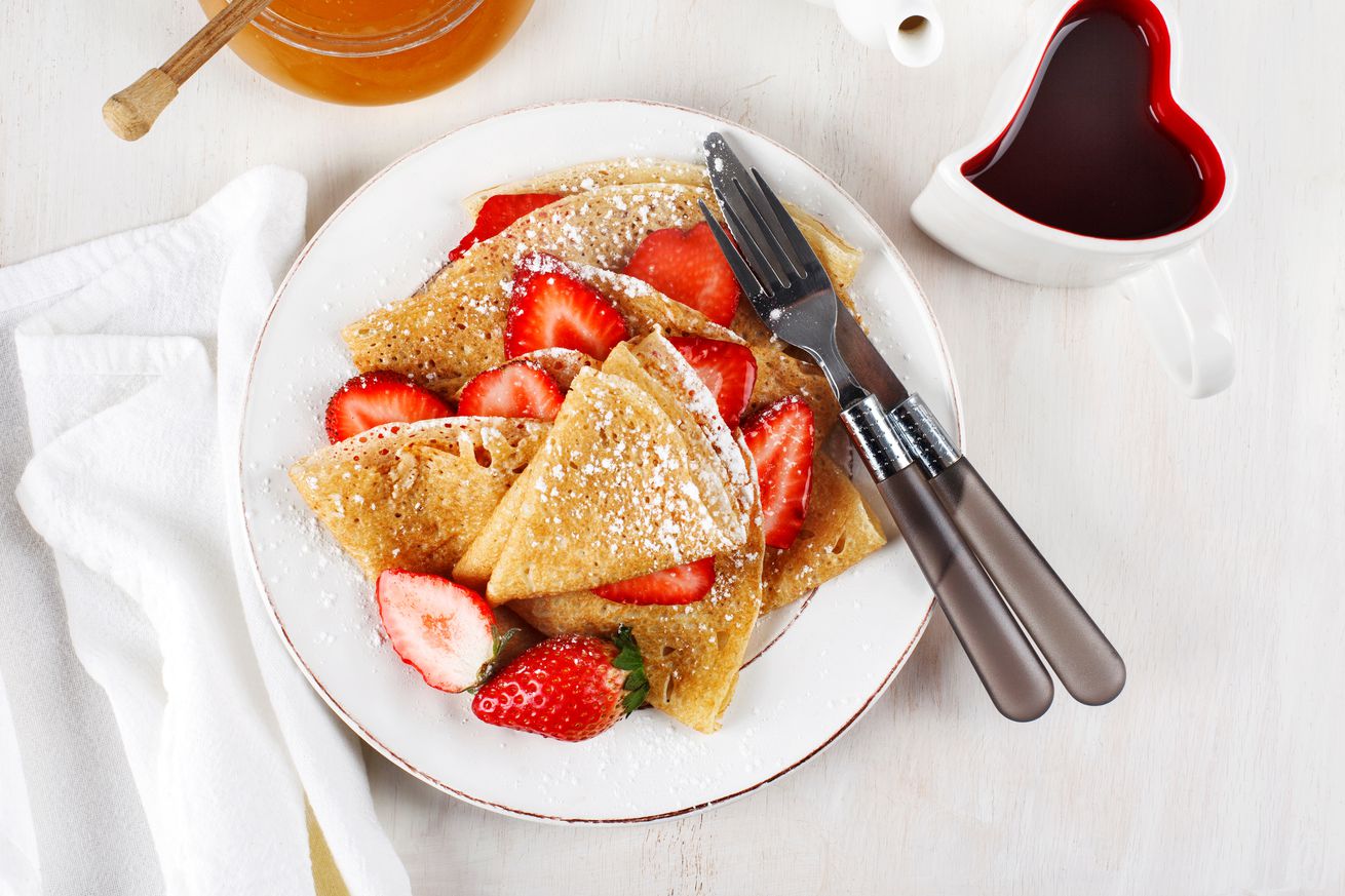 Crepes with strawberries on white background. top view.