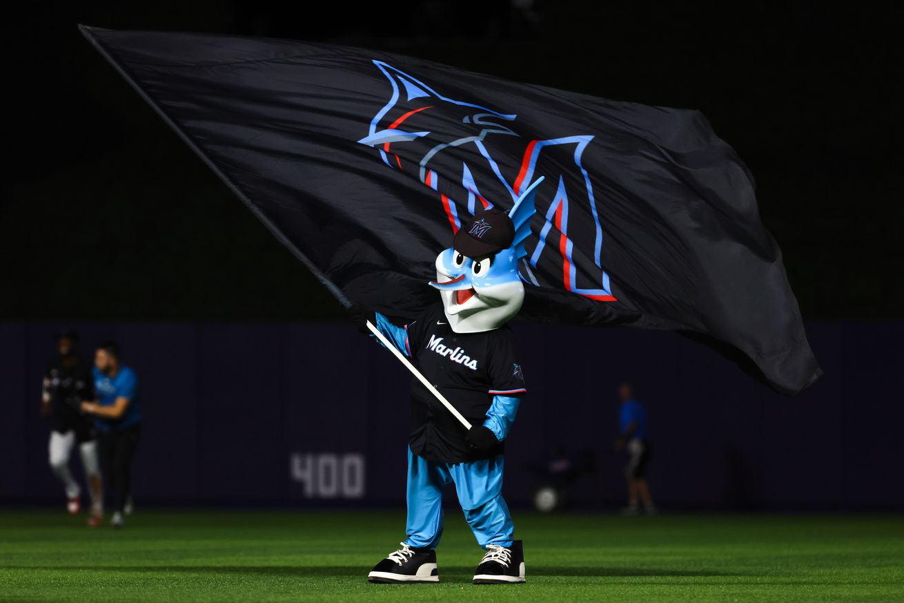 Billy the Marlin celebrates with a team flag after the game