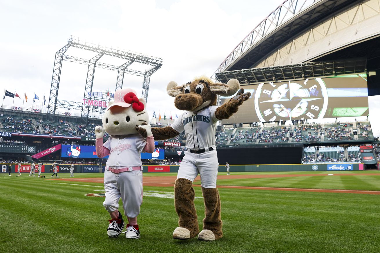 The Hello Kitty mascot poses for a photo with the Seattle Mariners team mascot Moose, right, after throwing out the first pitch before a game against the Athletics at T-Mobile Park.
