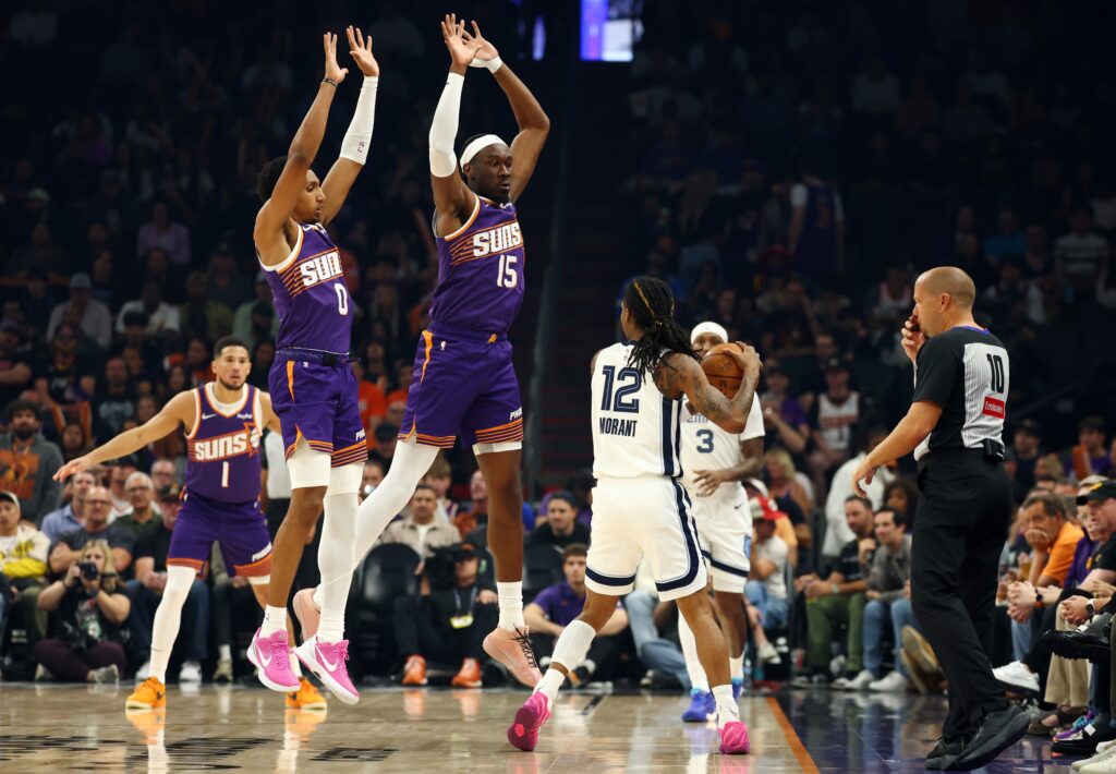 Oct 29, 2025; Phoenix, Arizona, USA; Memphis Grizzlies guard Ja Morant (12) against Phoenix Suns center Mark Williams (15) and forward Ryan Dunn (0) during the first half at the Mortgage Matchup Center. Mandatory Credit: Mark J. Rebilas-Imagn Images